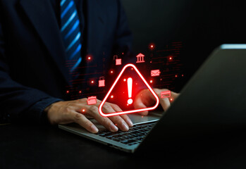Businessman typing on laptop with warning alert sign, symbolizing cybersecurity threat, data breach, hacking risk, malware attack, and online fraud prevention in digital technology.