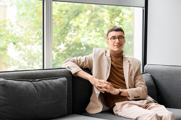 Obraz premium Portrait of handsome businessman sitting on sofa in conference hall