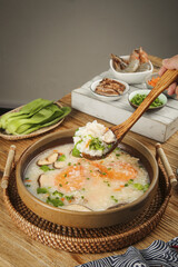 Delicious Seafood Congee with Shrimp and Shiitake Mushrooms in Traditional Clay Bowl