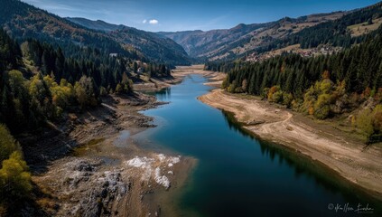 Obraz premium Serene mountain lake, low water levels reveal exposed lakebed