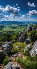 Obraz premium Mountaintop vista, path winds through rocks and grasses, valley below