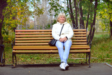 Authentic candid portrait of pensive attractive mature woman with blond hair with a quiet smile....