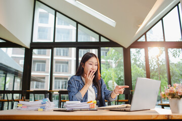 Asian businesswoman is working in office. She is very excited and happy that his business is...