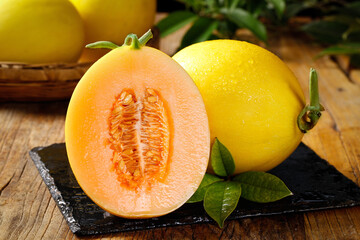 Fresh Golden Honeydew Melon Halves with Sweet Orange Flesh on Slate Board