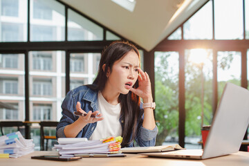 Asian businesswoman is working in office. She is very excited and happy that his business is...