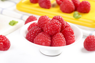 Fresh Red Raspberries in White Bowl with Berry Cake in Background