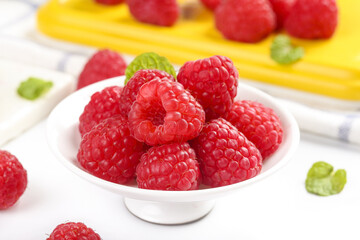 Fresh Red Raspberries in White Bowl with Colorful Berries and Mint Leaves