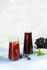 Dark grape juice and syrup with fresh grapes and mint - refreshing summer beverage concept