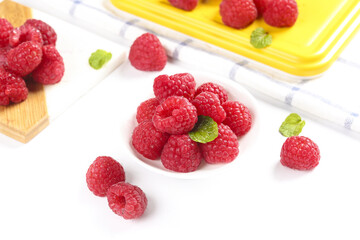 Fresh Red Raspberries with Mint Leaves in White Bowl on Clean Background