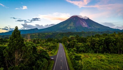 Scenic Road Leading to Majestic Volcano Under a Dramatic Sky.