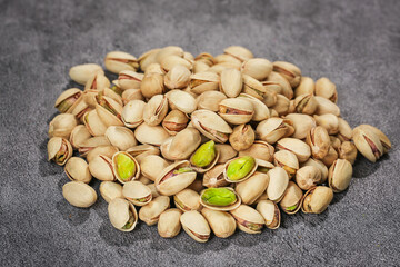 Roasted Salted Pistachios with Green Kernels on Dark Background - Healthy Nuts Snack Food