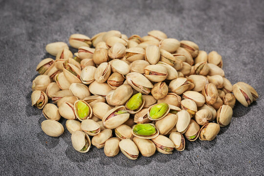 Roasted Salted Pistachios with Green Kernels on Dark Background - Healthy Nuts Snack Food