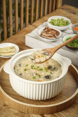 Delicious Chinese Congee Rice Porridge Breakfast with Vegetables and Side Dishes in Sunshine