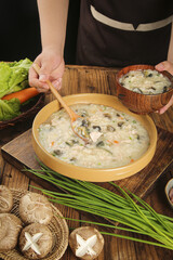 Traditional Chinese Congee with Lean Pork and Eggs Breakfast Porridge in Wooden Bowl