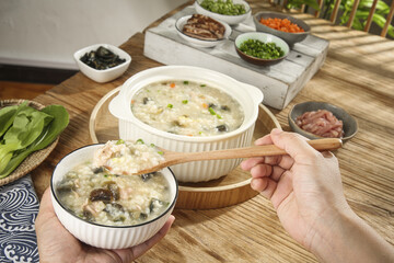 Traditional Chinese Congee Rice Porridge Breakfast Display with Chopsticks and Toppings in Sunshine
