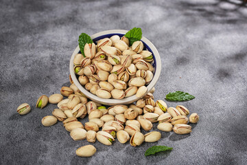 Fresh Roasted Pistachios in Bowl with Mint Leaves - Healthy Nuts Snack Food Photography