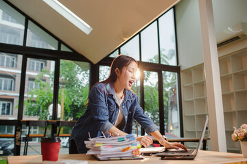 Asian businesswoman is working in office. She is very excited and happy that his business is...
