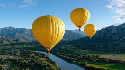 Fototapeta premium Yellow hot air balloons float over scenic valley with mountains and river, creating serene