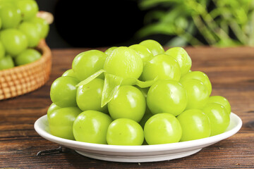 Fresh Green Seedless Grapes on White Plate - Healthy Organic Fruit on Wooden Table
