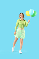 Beautiful woman with balloons on blue background