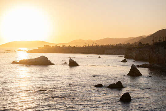 Sunset waves crash along the rugged coast of Pismo Beach, California, USA. - Powered by Adobe