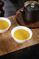 Traditional Chinese Tea Ceremony Set with Premium Puerh Tea and Handmade Wicker Teapot on Bamboo Mat