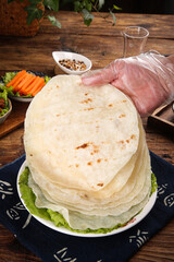 Fresh Flour Tortillas Stack with Ham and Vegetables on Rustic Wooden Table