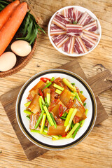 Wood-fired smoked bacon pancetta dish with vegetables and garlic on rustic wooden background
