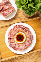 Sliced Raw Bacon with Sauce and Fresh Lettuce on Wooden Table - Cold Meat Preparation