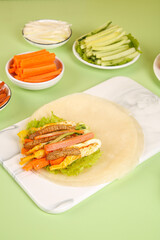 Healthy Whole Wheat Burrito with Fresh Vegetables and Grilled Meat on Green Background