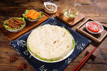 Flour Tortilla Wraps with Vegetables and Dipping Sauce on Wooden Table Asian Fusion Meal