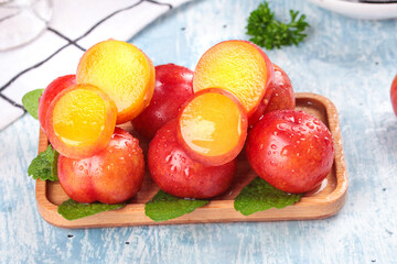 Fresh Red Plums Stuffed with Orange Spheres on Wooden Tray - Creative Fruit Presentation