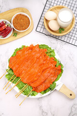 Raw Meat Skewers with BBQ Spices and Ingredients on Marble Kitchen Counter Top View