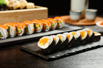 Fresh Japanese Sushi Rolls with Seaweed on Black Slate Serving Boards