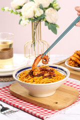Spicy Squid Pasta with Tentacles Being Eaten with Chopsticks - Seafood Noodle Dish