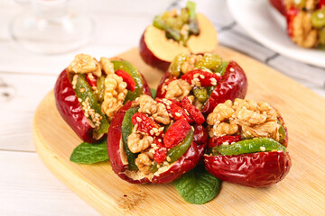 Stuffed Red Dates with Walnuts and Dried Fruit Traditional Xinjiang Chinese Dessert on Wooden Board