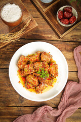 Braised Pork Chops with Garlic and Fresh Herbs on Rustic Wooden Table