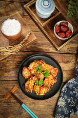 Fried Garlic Ribs Dish with Rice and Traditional Asian Ingredients on Wooden Table