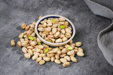 Fresh Green Pistachios in Bowl - Healthy Salted Nuts Snack on Gray Kitchen Counter