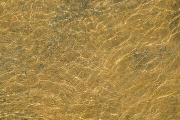 Background pattern and texture of river ripples and the sparkle of sunlight on the shallow...