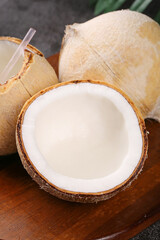 Fresh Coconuts with Coconut Water and Pink Straw on Wooden Table