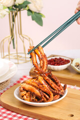 Spicy Glazed Squid Tentacles with Chopsticks - Asian Seafood Dish on Wooden Board