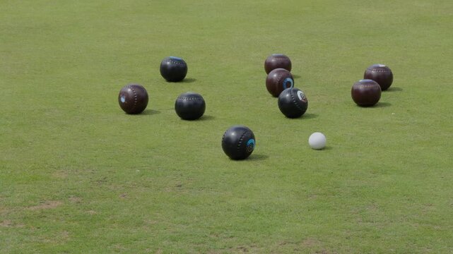 Multiple croquet balls competing for position on vibrant green grass field