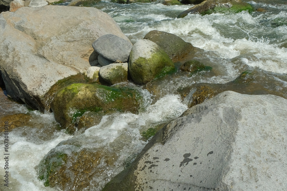 Poster view of large rocks on the edge of a clear mountain river. for advertising product placement design 