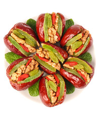 Stuffed Dates with Walnuts and Dried Fruits Arranged in Decorative Flower Pattern on White Background