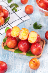 Fresh Red Plums from Guangdong China on Wooden Board with Water Droplets