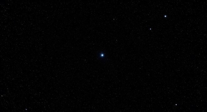 A clear night sky showing a few distant stars against a deep black background. A minimal concept of space, astronomy, and the vast universe.