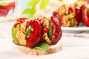 Red Xinjiang Dates Stuffed with Walnuts and Dried Fruit on Wooden Board - Traditional Chinese...