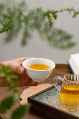 Traditional Chinese Tea Ceremony with Pu-erh Tea in White Porcelain Cup and Glass Teapot on Wooden Tray