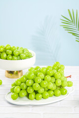 Fresh Green Seedless Grapes with Tropical Palm Leaf Shadow on White Background